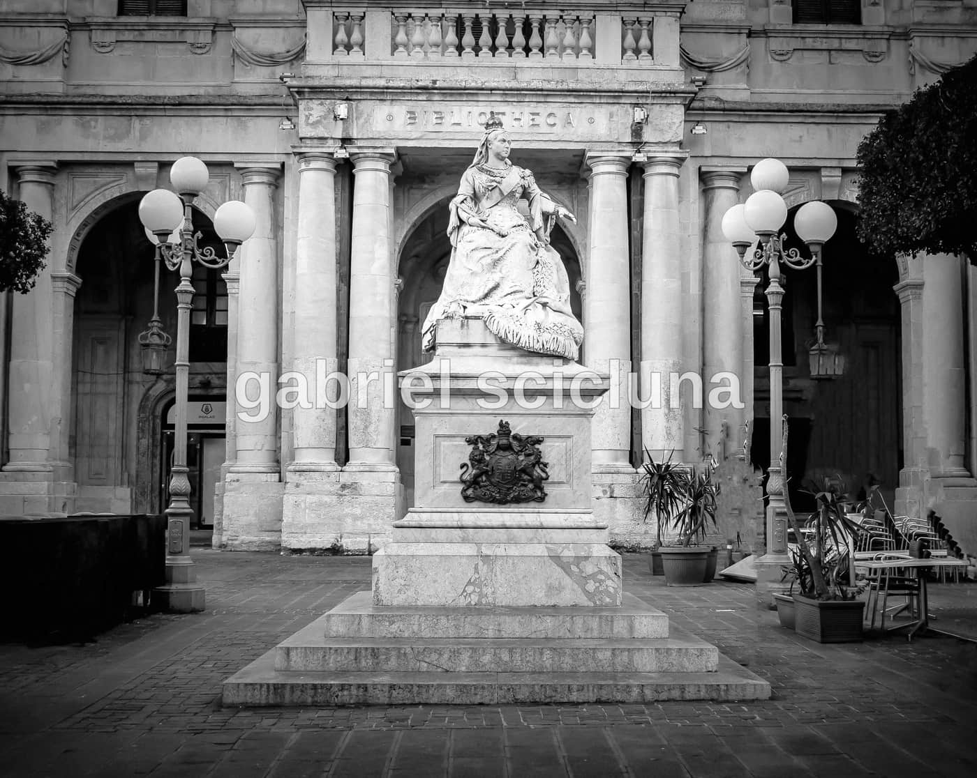 A monochrome view of Pjazza Regina in Valletta, documenting the public square and its sculptural details.